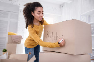 A girl storing dishes for storage.